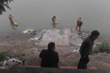 Des adeptes du naturisme se baignent dans le fleuve Rouge sous le regard de passants, le 11 décembre