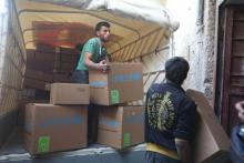 Des Syriens déchargent de l'aide humanitaire près de la ville d'Al-Nashabia, dans la région rebelle 