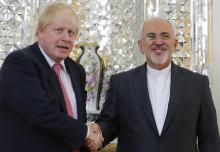 Le ministre britannique des Affaires étrangères Boris Johnson (G) serre la main à son homologue iran