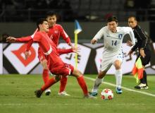 Le défenseur sud-coréen Go Yohan (#14) face au milieu nord-coréen Ri Un-Chol (L) durant le match ent