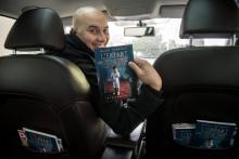 Chauffeur VTC et écrivain, Brahim Kermaoui pose avec son livre "l'Enfant égaré" à Asnières-sur-Seine