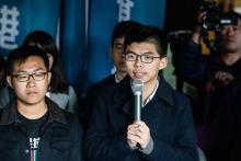 Les militants pro-démocratie Joshua Wong (c) et Raphael Wong (g) devant la Haute cour, le 17 janvier 2018 à Hong Kong