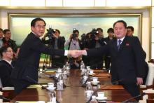 Le ministre sud-coréen de l'Unification Cho Myung-Gyun (G) serre la main du responsable de la délégation nord-coréenne Ri Son-Gwon (D) lors d'une rencontre à Panmunjom, le 9 janvier 2018
