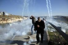 Des Palestiniens courent pour échapper à des tirs de gaz lacrymogène lors de heurts avec les forces israéliennes le 13 janvier à Nabi Saleh, en Cisjordanie occupée, après une manifestation réclamant l