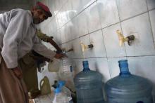Un homme remplit des bouteilles d'eau dans une station de traitement à Islamabad, le 14 décembre 2017