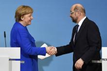La chancelière allemande Angela Merkel serre la main du socio-démocrate Martin Schulz, après une conférence de presse commune à Berlin, le 12 janvier 2018