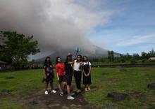 Des touristes se prennent en photo devant le volcan à Daraga, dans le centre des Philipines, le 30 janvier 2018