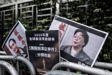 Des pancartes montrant Gui Minhai (D) sont disposées devant le bureau de liaison de la Chine à Hong 