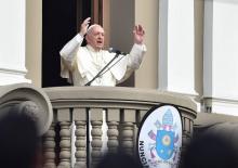 Le Pape François salue la foule, tenant une croix arborant l'inscription "je vous offre ma paix", près d'un temple à Santiago du Chili, le 17 janvier 2018