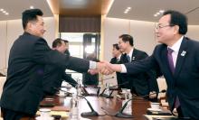 This handout photo provided by South Korean Unification Ministry shows North Korean delegation members (L) shaking hands with South Korean delegation members (R) during their working-level talks at th