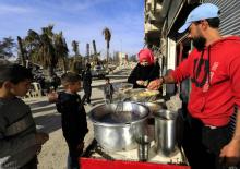Des enfants syriens achètent des falafels dans l'un des plus célèbres restaurants de ces boulettes de pois chiches frites, à Raqa le 9 janvier 2018
