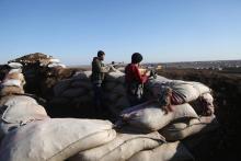 Des rebelles syriens alliés de la Turquie positionnés dans la zone de Tal Malid, dans le nord de la Syrie, se préparent à tirer vers des positions d'une milice kurde dans la région d'Afrine le 20 janv