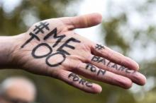 Une main arborant les expressions "#Me too" et #Balancetonporc pendant un rassemblement contre les v
