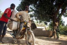 Des hommes profitent de la présence de Casques bleus pour transporter de la nourriture dans leur fuite du village de Bedaya, le 12 janvier 2018, dans le nord-ouest de la Centrafrique.