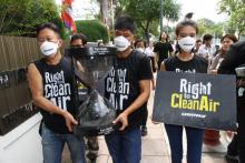 Une photo prise par Dailynews montre des militants de Greenpeace en train de livrer à la junte au pouvoir en Thaïlande un sablier en verre symboliquement rempli de l'air pollué de Bangkok, le 22 févri