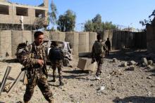 Les forces de sécurité afghanes inspectent le site d'un attentat à la voiture-suicide qui a fait huit blessés à Lashkar Gah, capitale de la province du Helmand, le 24 février 2018