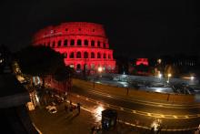 Le Colisée de Rome illuminé en rouge, à l'initiative de la fondation "Aide à l'Eglise en détresse", le 24 février 2018. 'une People gather for a ceremony outside of the Roman Colosseum, illuminated in