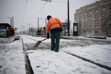 Un agent enlève la neige des rails du tram à Tours, le 7 février 2018