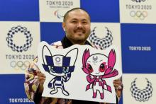 Le Japonais Ryo Taniguchi, créateur des mascottes choisies par des écoliers japonais pour incarner l'Olympiade, pose avec son oeuvre, le 28 février 2018 à Tokyo
