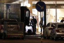Des policiers surveillent, le 8 avril 2017, le camion volé utilisé la veille pour foncer sur la foule dans une rue commerçante de Stockholm, tuant cinq personnes.