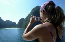 Une touriste prend une photo de la baie Maya, dans le sud de la Thaïlande, rendue célèbre par le film La Plage, avec Leonardo DiCaprio