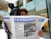 Une femme lit la nouvelle maquette du quotidien français le Figaro, le 02 octobre 2005 dans les nouveaux locaux du quotidien à Paris