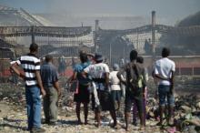 Des haïtiens regardent les ravages d'un incendie qui a détruit le marché en fer à Port-au-Prince, le 13 février 2018