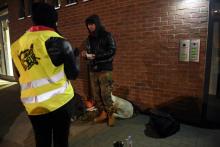 Une volontaire des Restos du Coeur apporte un repas à un sans-abri à Strasbourg, où la température est descendue à -7 degrés en soirée le 26 février 2018