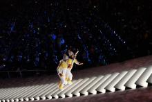 Deux hockeyeuses, l'une du Nord, l'autre du Sud, main dans la main montent vers la vasque olympique lors de la cérémonie d'ouverture des JO-2018, le 9 février 2018 à Pyeongchang