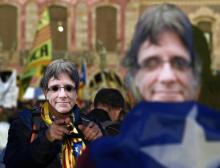 Des manifestants portant des masques à l'effigie du leader séparatiste catalan Carles Puigdemont dans les rues de Barcelone, le 30 janvier 2018