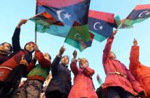 Des enfants libyens brandissent le drapeau national pour célébrer l'anniversaire du début de la révolution contre le dictateur Mouammar Kadhafi en 2011, le 16 février 2018 à Tripoli