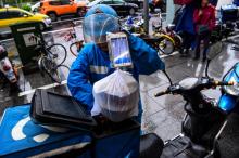 Un livreur s'apprête à partir distribuer une commande de plats alimentaires à un restaurant à Shanghai, le 16 octobre 2017