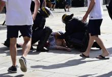 Des policiers autour du supporter anglais Andrew Beache, roué de coups lors de violences entre supporters russes et anglais avant un match de l'Euro, le 11 juin 2016 à Marseille