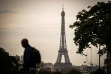 Un touriste passe devant la Tour Eiffel à Paris, le 1 août 2017