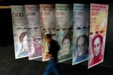 Des bolivars reproduits sur des affiches devant la Banque centrale de Caracas, le 31 janvier 2018. La devise vénézuelienne a perdu 86,6% de sa valeur face à l'euro en cinq mois