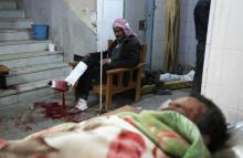 Des Syriens blessés par les raids du régime attendent dans une clinique de forture d'être soignés à Kafr Batna dans le fief rebelle de la Ghouta orientale, le 21 février 2018