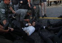 La police israélienne police soulève des manifestants juifs ultra-orthodoxes qui bloquent une artère à Bnei Brak, près de Tel-Aviv, le 12 mars 2018