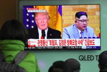 Des Sud-Coréens regardent sur un écran de télévision les photos du président américain Donald Trump et du leader nord-coréen après l'annonce de leur prochaine rencontre, le 9 mars 2018 dans une gare d