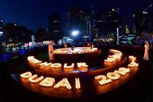 A Dubai, des gens ont allumé des bougies alors que les gratte-ciel s'étaignaient le 24 mars 2018 à l'occasion d'Earth Hour.