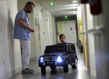 Un petit garçon de deux ans teste une voiturette électrique avant d'aller en salle d'opération, le 2 février 2018 à l'hôpital de Valenciennes