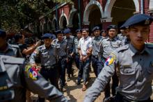 Le journaliste Wa Lone (C) est escorté le 21 mars 2018 par la police birmane pour une nouvelle audience dans son procès