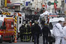 Des policiers et pompiers sur les lieux d'une opération des forces spéciales, le 18 novembre 2015, contre un appartement à Saint-Denis à la recherche des auteurs des attentats à Paris cinq jours avant