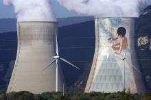 Des éoliennes devant les cheminées d'une centrale nucléaire, le 7 avril 2011 à Cruas
