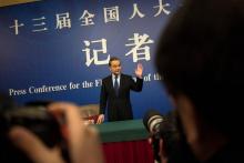 Le ministre chinois des Affaires étrangères, Wang Yi, salue les photographes à son arrivée pour une conférence de presse le 8 mars 2018, à Pékin.
