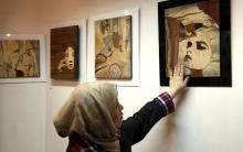 Des victimes d'attaques à l'acide en Iran présentent leur travail à la galerie Ashianeh dans la capitale Téhéran, le 28 février 2018