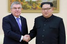Photo non datée et publiée par l'agence de presse officielle nord-coréenne KCNA du président du CIO Thomas Bach (g) et du dirigeant nord-coréen Kim Jong Un (d)