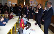 Emmanul Macron (au centre) et le ministre de l'Education nationale Jean-Michel Blanquer (droite) discutent le 15 mars 2018 avec des enfants d'une école prise de Rilly-sur-Vienne dans l'Indre