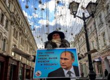 Une militante distribue des tracts en faveur de Vladimir Poutine dans une rue de Moscou, le 16 mars 2018