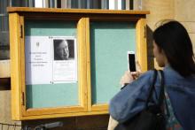 Une étudiante photographie l'affiche annonçant la mort de Stephen Hawking au Gonville and Caius College de Cambridge, le 14 mars 2018