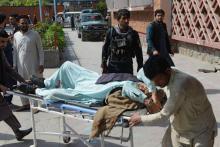 Des volontaires afghans conduisent un homme à l'hôpital après une explosion à Jalalabad le 19 mars 2018.